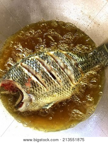 Fried fish with hot vegetable oil in pan