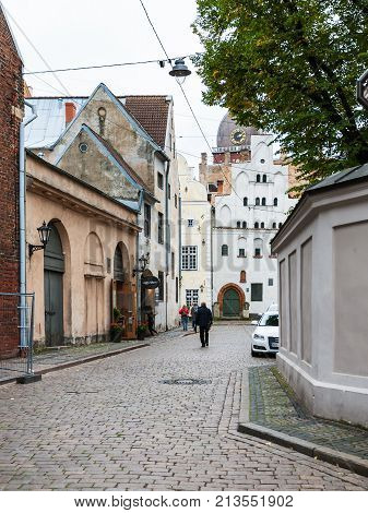 Tourists Walk To Three Brothers Houses In Riga