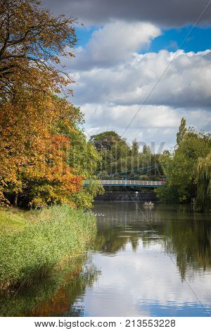 River Leam flowing through Jephson Gardens, on a beautiful Autumn day, golden tree leaves Royal Leamington Spa, Warwickshire, England, UK, September, 2017