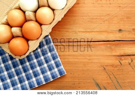 Egg carton with  blue napkin on wood board,top view  for copy text space