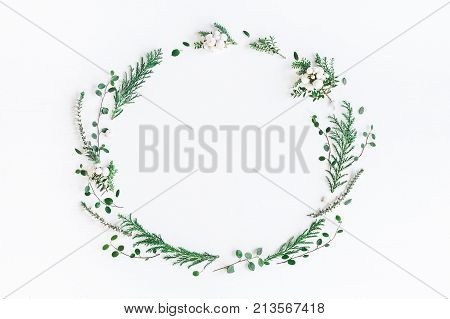 Christmas composition. Wreath made of winter plants flowers berries on white background. Christmas winter new year concept. Flat lay top view copy space