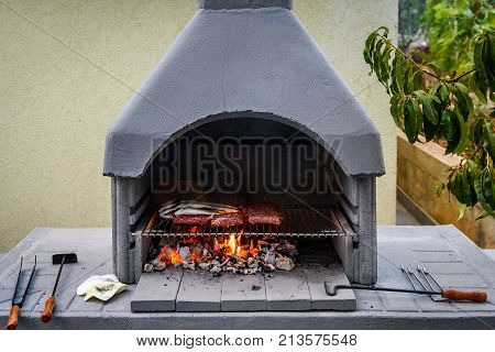 Barbecue In Built Barbecue Grill Fireplace With Fish And Chevaps.