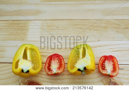 Yellow sweet pepper and red tomato on wood board ,top view for copy space