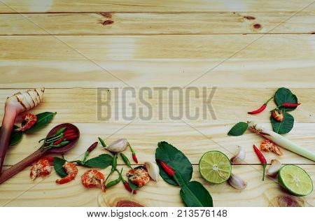 Background of spicy ingredients chili ,lime,kaffir lime ,dry shrimp Thai herb food on wood board,top view for copy space
