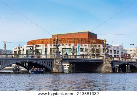 Amsterdam, Netherlands - April 2, 2016: Opera house, canal and bridge panorama in Holland