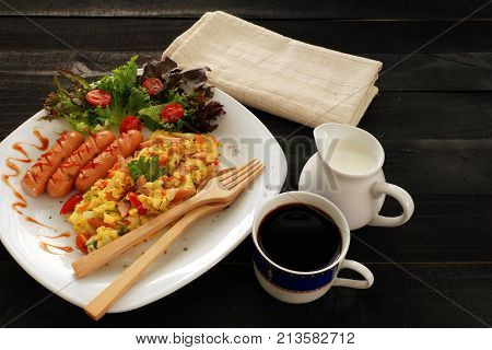Omelette  with onion, tomatoes,sausage and fresh salad on white plate,coffee and cream on breakfast for business man background