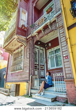 ISTANBUL TURKEY: Beautiful girl sitting at porch of traditional wooden house in Kuzguncuk district on October 10 2017