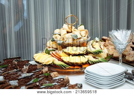 Fresh fruits and berries of different bright colors cut in small pieces are served on a table