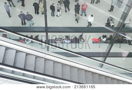 ZAGREB AIRPORT - 24 APRIL 2017: Aerial view of passengers waiting in hall, escalators passing.