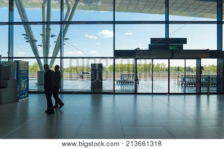 ZAGREB AIRPORT - 24 APRIL 2017: Businessmen walking in front of glass door entrance.
