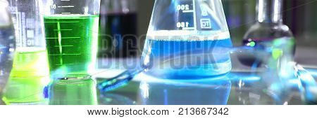 Chemical industry bulb with blue magenta pink liquid lab tubes stand on the table in the laboratory of liquid testing test development substances poisons additives stabilizers flavors house cleaning.