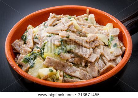 a crock pot  of valtellinese pizzoccheri on black