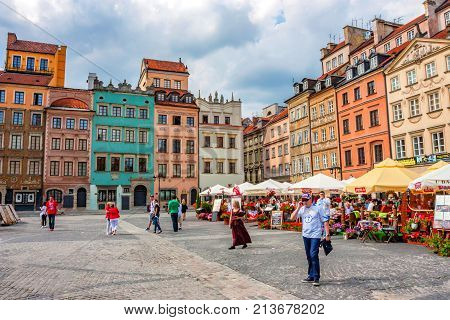 WARSAW, POLAND - JUNE, 2012: Beautiful view of Old Town market place on sunny day with lots of tourists
