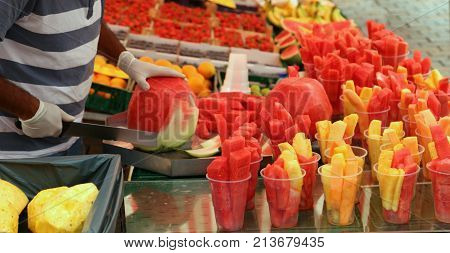 Man Cuts Watermelon With A Large And Sharp Knife To Prepare Frui