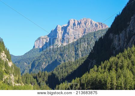 The view of the landscape with a green forest mountains and blue sky. Malga Ciapela Veneto Italy.