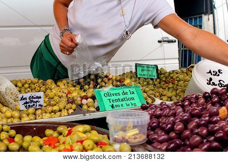 Valras-plage, Herault, France - Aug 25 2017: Woman Serving A Large Range Of Olives For Sale At An Op