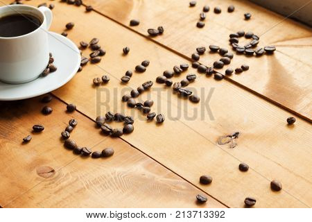 Coffee Cup And Coffee Beans On Wooden Table .