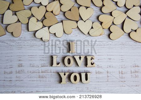 Heart shape from natural tree. Lovely heart shape by wooden small hearts on rustic wood table. Love theme concept with wooden hearts for Valentine's background and love theme. wooden leters i love you.