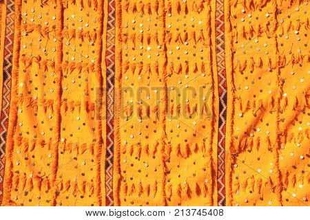Texture of berber traditional carpet of yellow color with geometric pattern and with shiny sequins, Morocco, Africa
