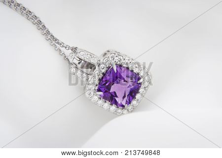 White gold pendant with rose violet amethyst and diamonds on soft blurred background