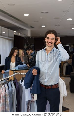 Handsome Business Man Wear Formal Suit Holding Jacket In Hands In Modern Menswear Shop Over Latin Male Paying For Clothes