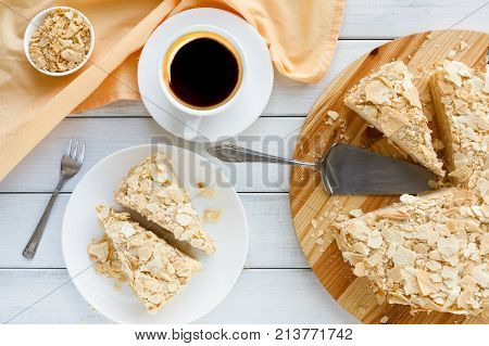 Classic Napoleon cake with coffee cup top view. Traditional millefeuille dessert with puff pastry and custard, russian cuisine treat, copy space