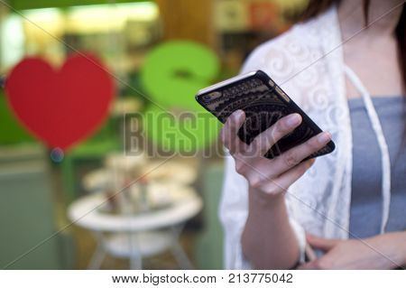 A woman is using her cellphone to hail a cab