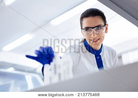 Where is it.  Charming young budding researcher looking for  right reagent for conducting tests while  examining stickers