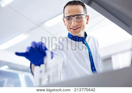 I found it.Happy cheerful male scientist deciding about medication while wearing medical glasses and holding container