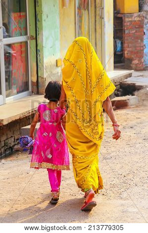 Local woman with a girl walking in the street in Taj Ganj neighborhood of Agra Uttar Pradesh India. Agra is one of the most populous cities in Uttar Pradesh