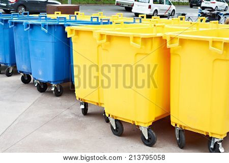 Yellow and blue plastic garbage cans on the city street