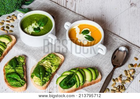Vegetarian healthy food. Soup and vegan sandwiches. Different sandwiches with avocado. Brunch on white wooden background.
