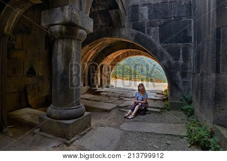 HAGHPAT MONASTERY, ARMENIA - 01 AUGUST 2017: Young woman enjoying natural light effects inside Haghpat Monastery on Northern Armenia