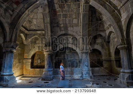 HAGHPAT MONASTERY, ARMENIA - 01 AUGUST 2017: Young woman enjoying natural light effects inside Haghpat Monastery on Northern Armenia