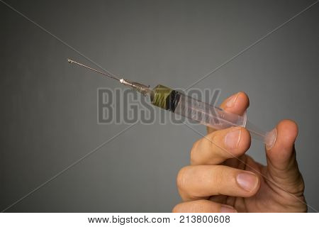 syringe with a needle for a prick in the hand