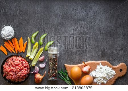 Composition of raw meat with vegetables and spice on wooden background. Top view. Copy space. Still life. Flat lay.