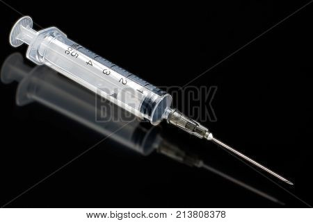medical syringe on a dark background with reflection