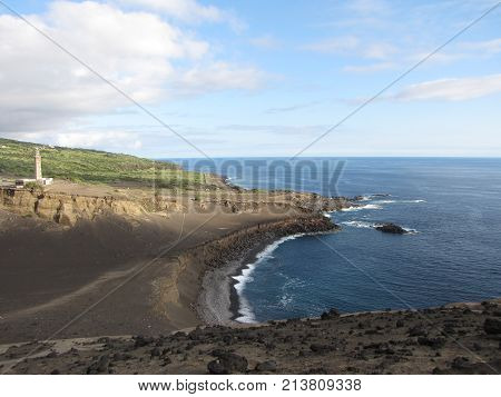 Lighthouse of the Capelinhos seen from the volcano ridge