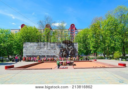 POLOTSK BELARUS - MAY 19 2017: Unknown people are resting in open air near Monument to Liberators of Polotsk on Freedom square Belarus