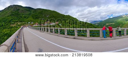 TARA RIVER CANYON MONTENEGRO - SEPTEMBER 12 2017: Unknown tourists on famous Djurdjevic Bridge take pictures of Tara River canyon Montenegro