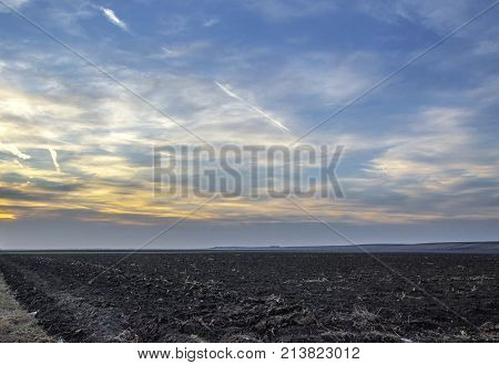 agriculture arable land field with sky clouds. agricultural landscape