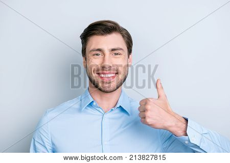 Close Up Portrait Of Happy Confident Smiling Employee Showing Thumb Up Hand Sign Standing On Grey Ba
