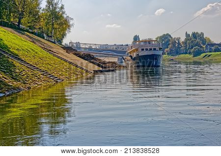 Old tourist boat anchored on the river Kupa on a beautiful sunny day.