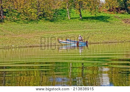 SISAK, CROATIA - September 30, 2017: Man fishing on the river Kupa on a beautiful sunny day.
