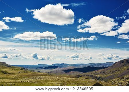 Travel to Iceland. road and river in a bright sunny mountain landscape. Vatna volcano covered with snow and ice on tne background.