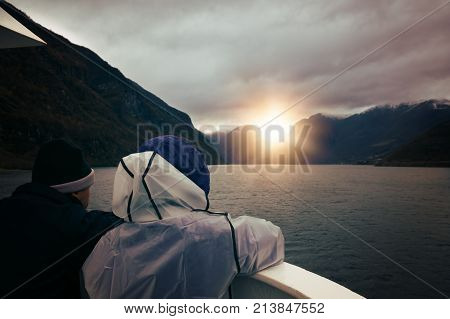 Middle aged couple admiring stunning scenery during Norway in a nutshell sightseeing cruise through the Aurlandsfjord and  narrow Naeroyfjord