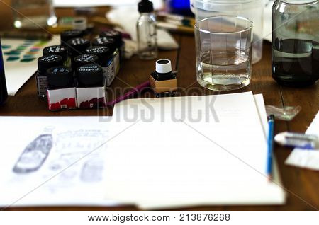 Watercolors on white paper and watercolors on the table.