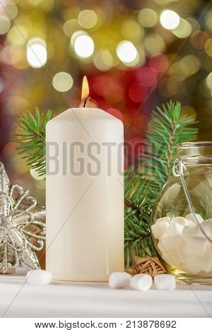Christmas candle on the background. Marshmallow in a jar.