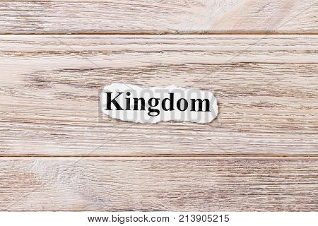 Kingdom of the word on paper. concept. Words of Kingdom on a wooden background.