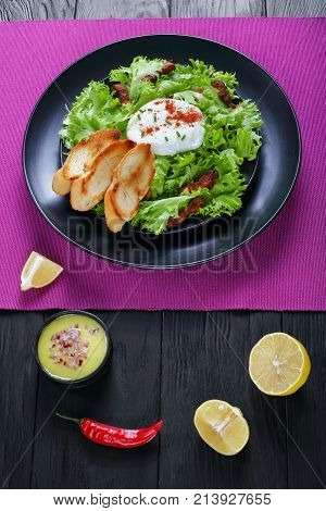 Classic Salad Lyonnaise On Black Plate